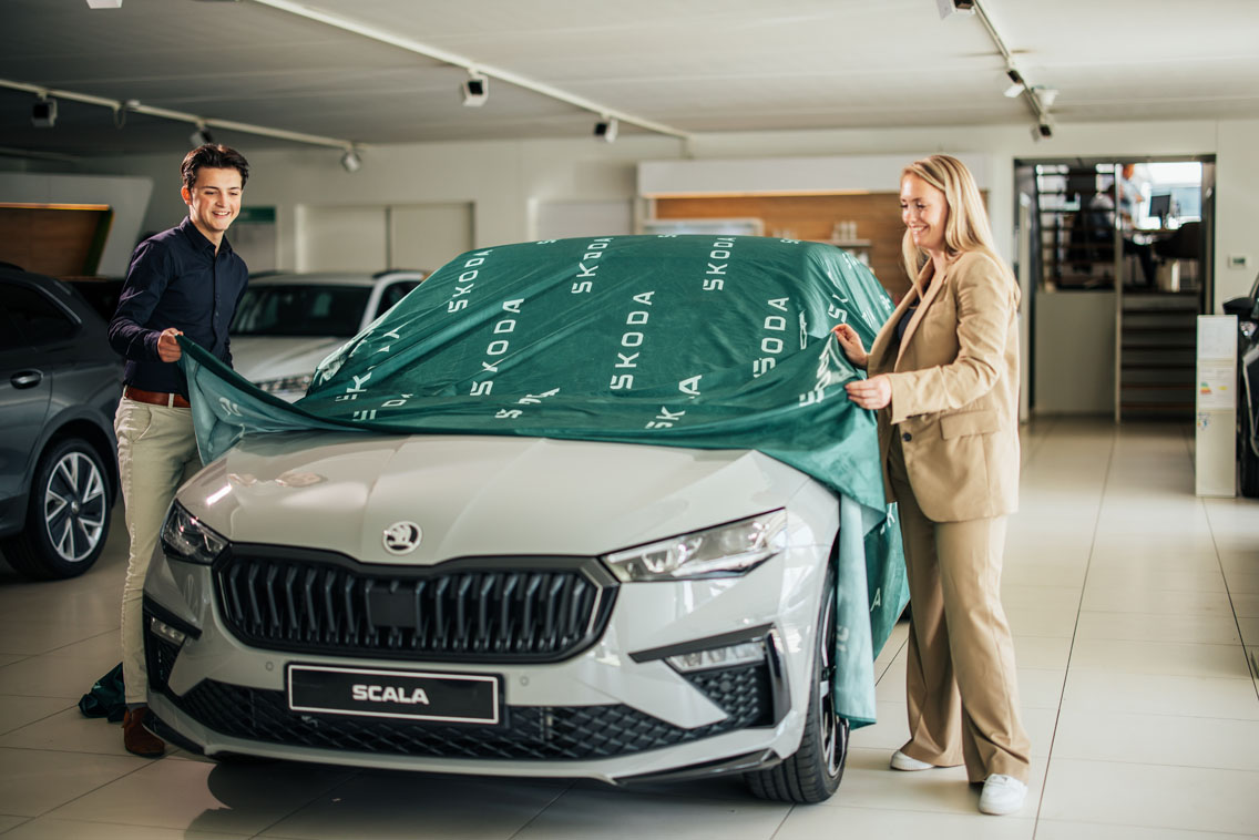 Man en vrouw halen een doek van een Skoda auto af