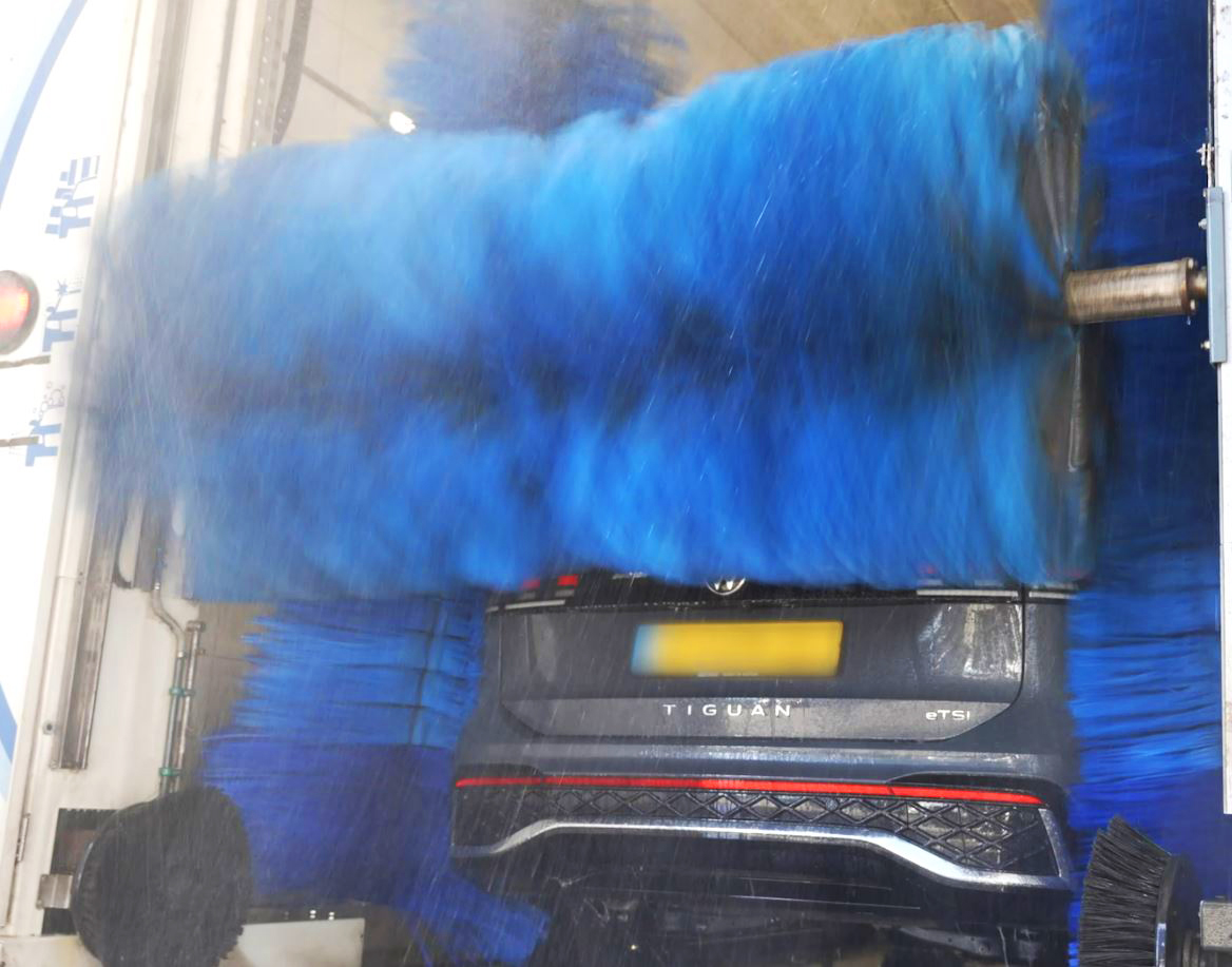 Autowasser achterkant van de auto in een wasstraat
